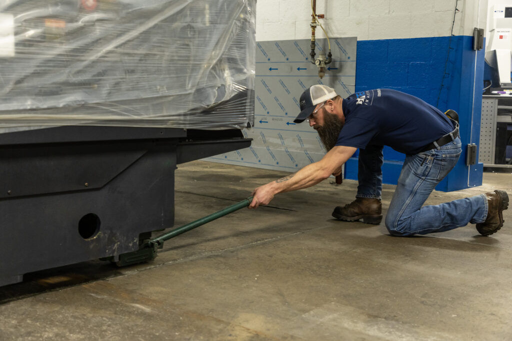 A man uses a lever to set a machine into place.
