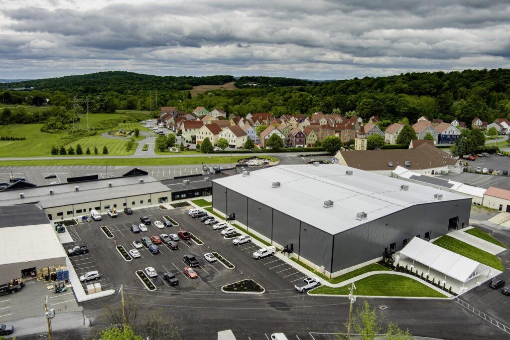A warehouse and parking lot with picturesque buildings in the background.