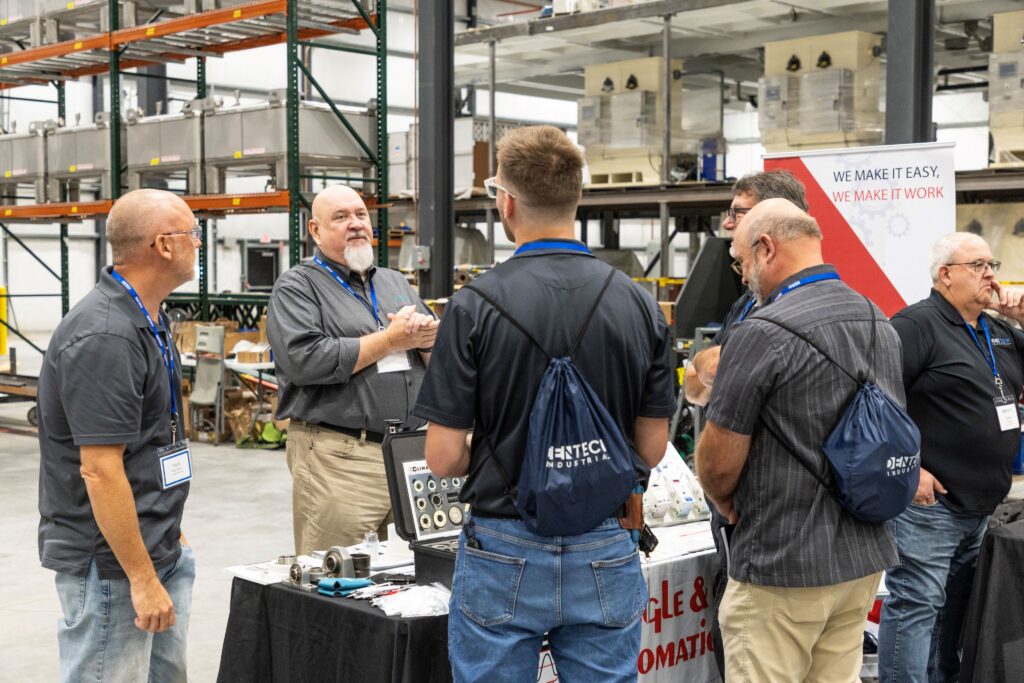 A group of people are chatting inside a warehouse