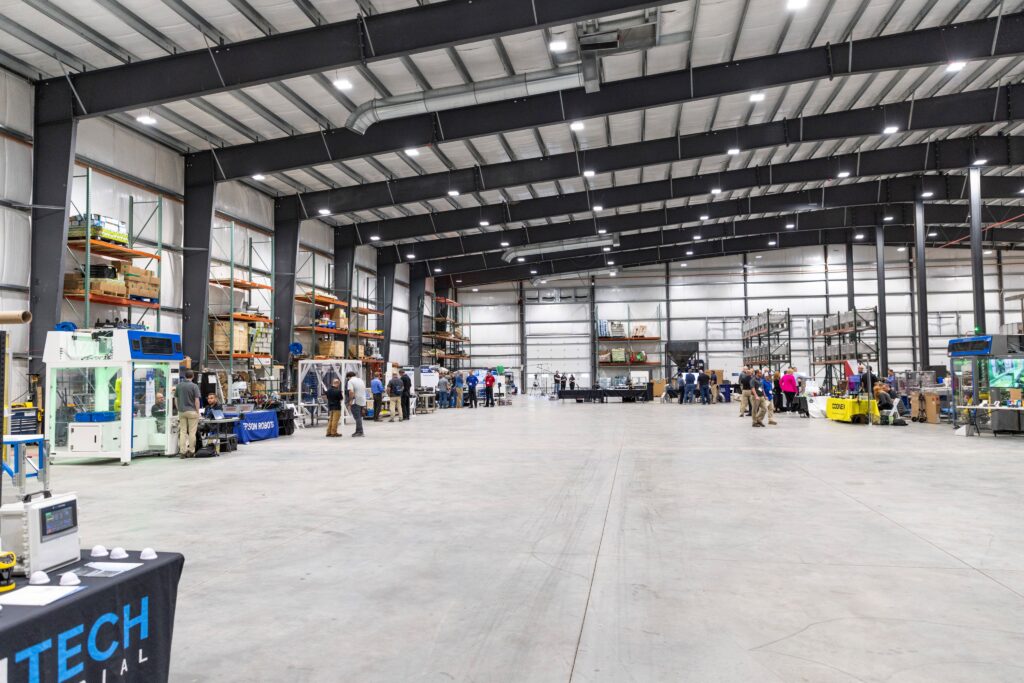 A large warehouse with tables and equipment set up around the perimeter