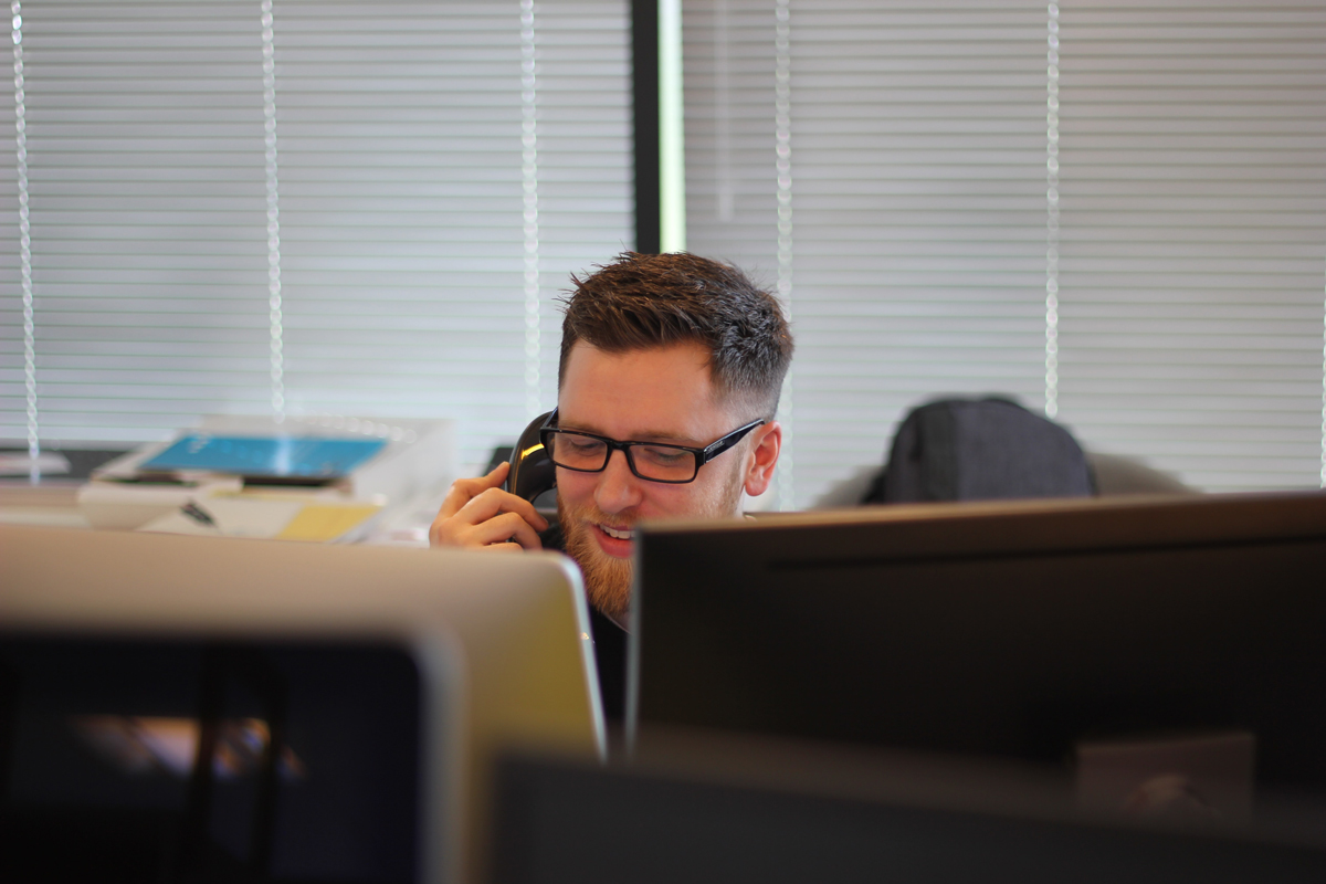 Man with glasses speaking on the phone