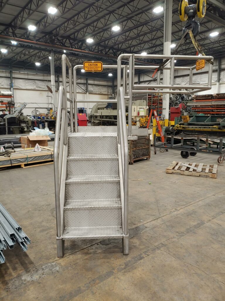 Stainless-steel fabricated platform (front view) in a warehouse