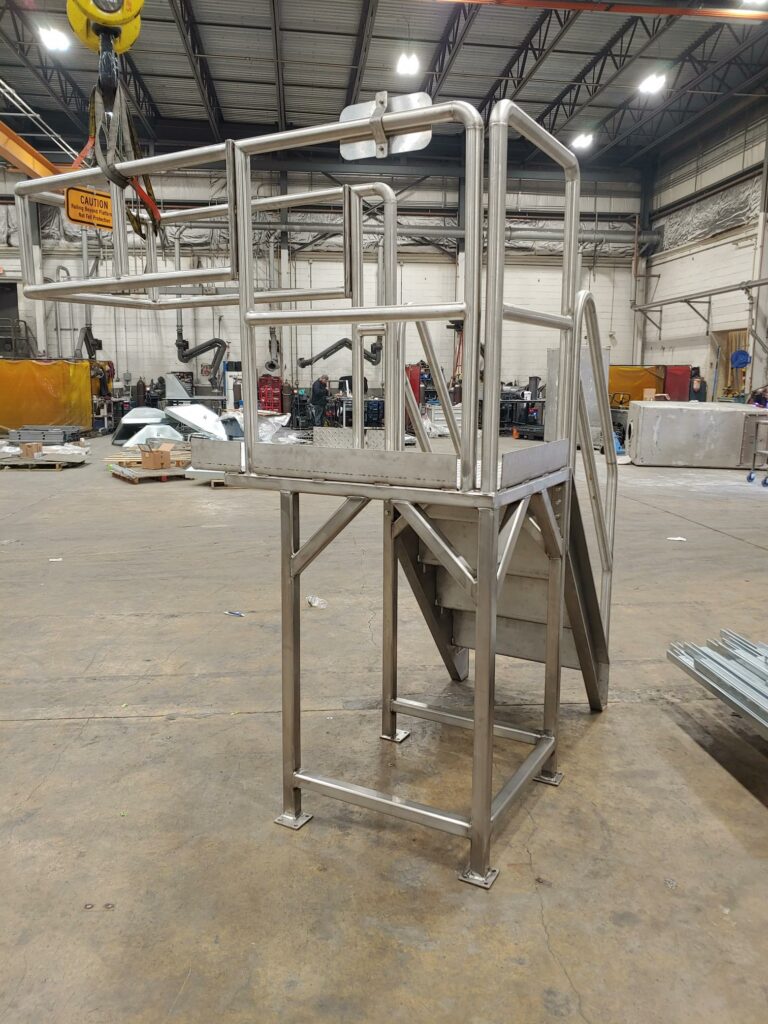 Stainless-steel fabricated platform (back view) in a warehouse